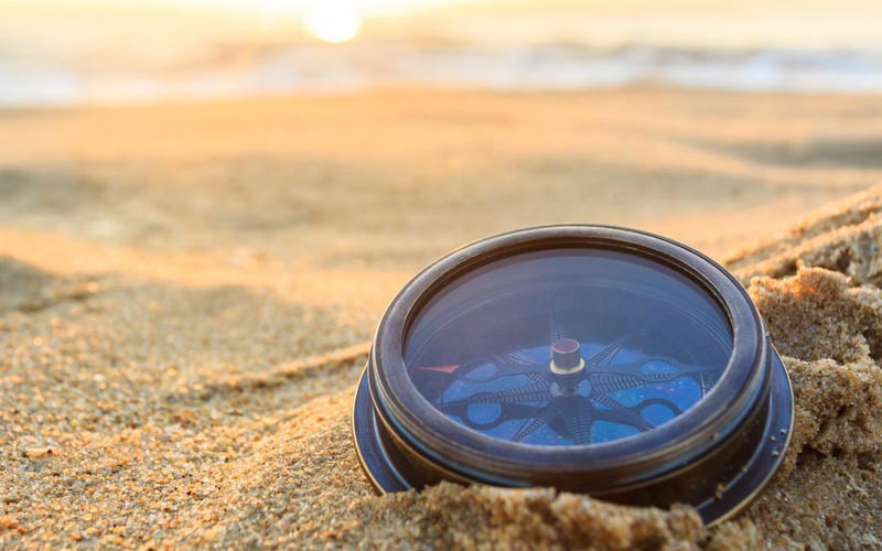 Compass in the sand on a beach, direction and therapeutic decisions